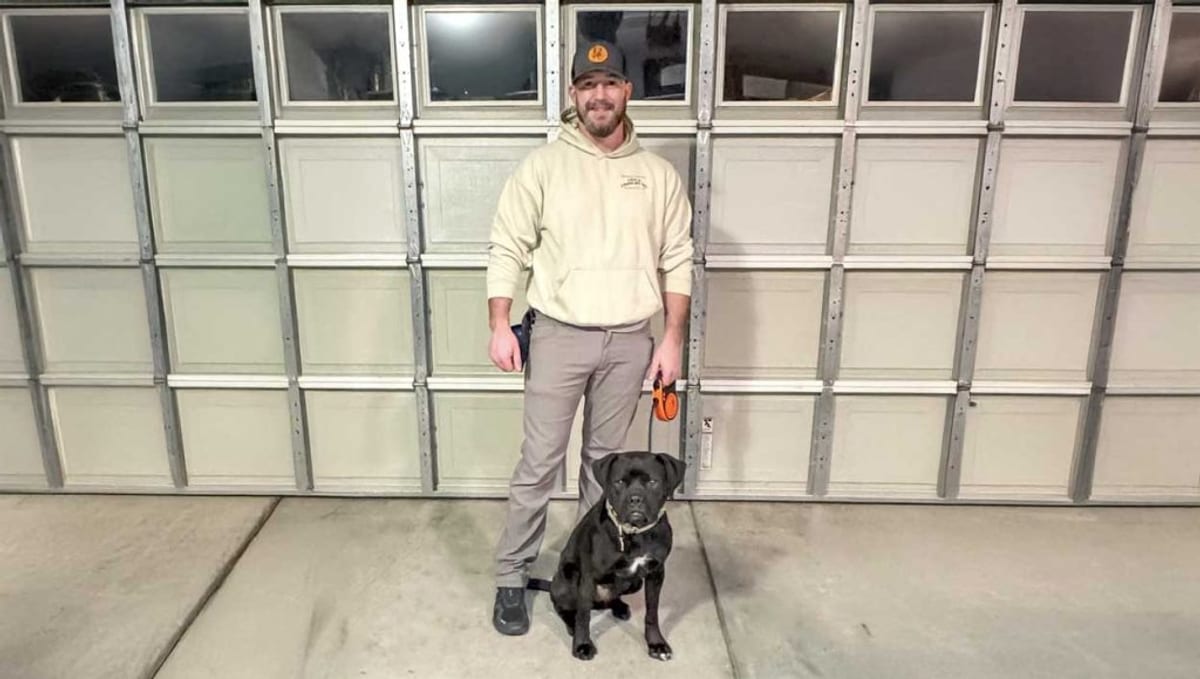 Trainer with black lab in formal stand
