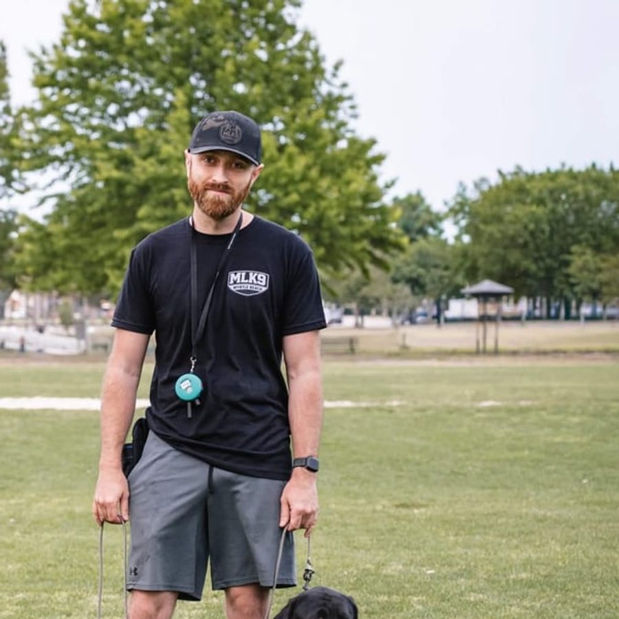 Zach, Lead Trainer at MLK9 Myrtle Beach, with his black lab